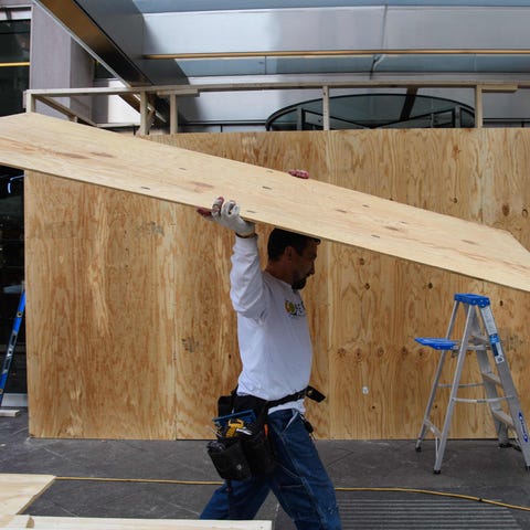 A worker carries a wooden board as office building