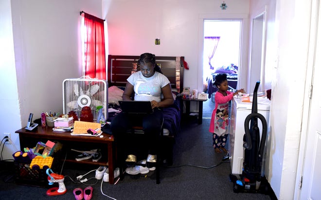 Raelin Powell attends remote classes at West Middle School in Binghamton, New York, as her niece, Phoenix Barnett, busies herself in the family's apartment on Oct. 15. Phoenix, 3, is also enrolled in online learning.