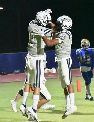 Junior Trey Rainey (22) celebrates with receiver Matthew Hall after Rainey scored against Cardinal Newman in Friday's 19-0 win.