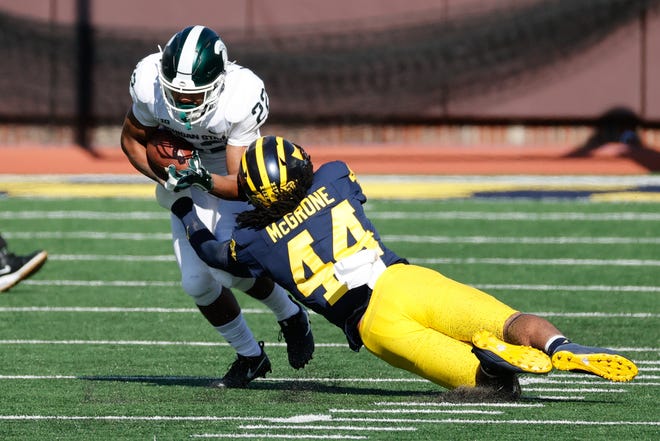 Michigan State running back Jordon Simmons is tackled by Michigan linebacker Cameron McGrone during the first half on Saturday, Oct. 31, 2020, at Michigan Stadium.