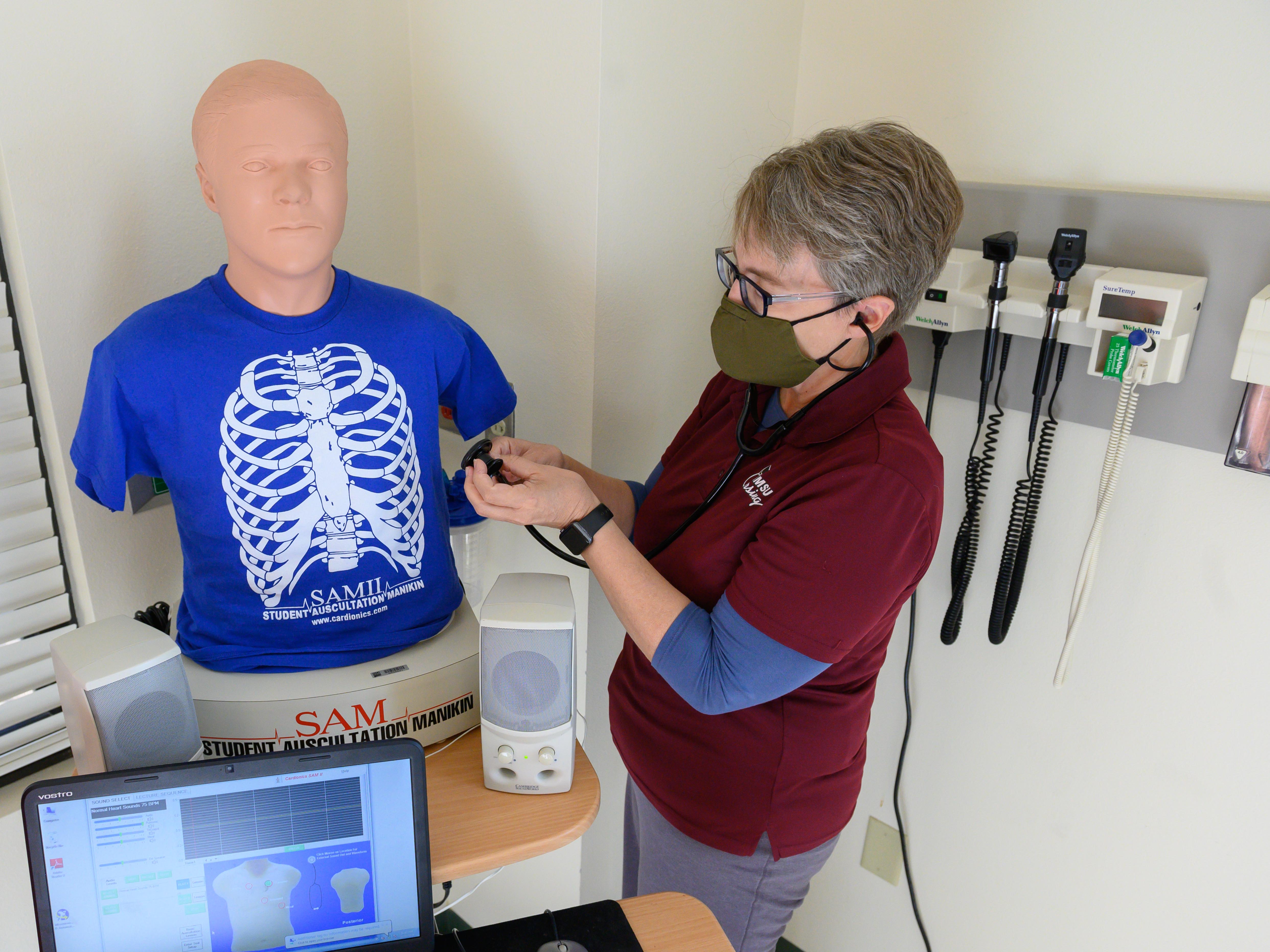 Alexa Doig, director of the School of Nursing at New Mexico State University, performs a physical assessment on a training mannequin inside of a lab at NMSU’s College of Health and Social Services in October 2020.