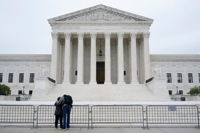 A woman and man pray outside the Supreme Court on Capitol Hill in Washington, Tuesday, Oct. 27, 2020, the day after the Senate confirmed Amy Coney Barrett to become a Supreme Court Justice. (AP Photo/Patrick Semansky) ORG XMIT: DCPS101