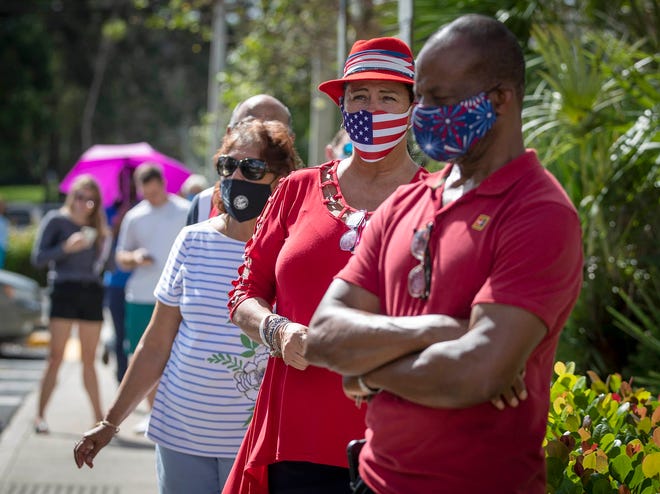 WELLINGTON -- Early voters stand in a line that snakes around the parking lot at the Wellington Branch Library last week. Early voters stood in line at mid-day an hour and a half to cast their vote.  [ALLEN EYESTONE/THE PALM BEACH POST]