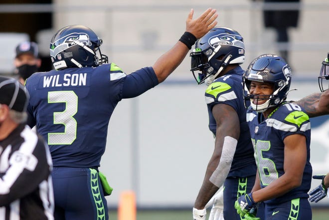 Seattle Seahawks quarterback Russell Wilson (3) celebrates with wide receiver DK Metcalf, center, after Wilson passed to Metcalf for a touchdown against the San Francisco 49ers during the first half of an NFL football game, Sunday, Nov. 1, 2020, in Seattle.