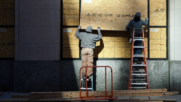 Workers board up windows on the Ohio Chamber of Co