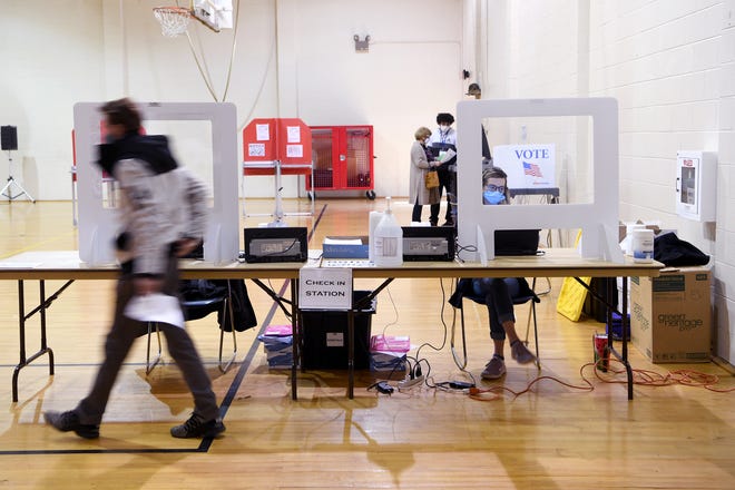 Voters check in before casting their ballots at the North Carolina Justice Academy in Edneyville on Election Day, Nov. 3, 2020. 