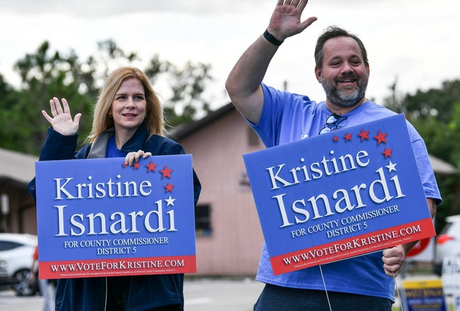 District 5 Brevard County County Commissioner Kristine Isnardi and Milo Zonka wave to voters outside the Greater Palm Bay Senior Center in Palm Bay on Tuesday. Mandatory Credit: Craig Bailey/FLORIDA TODAY via USA TODAY NETWORK