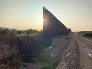 The sun sets over newly built sections of the border wall east of Sasabe, Arizona on Sept. 16, 2020.