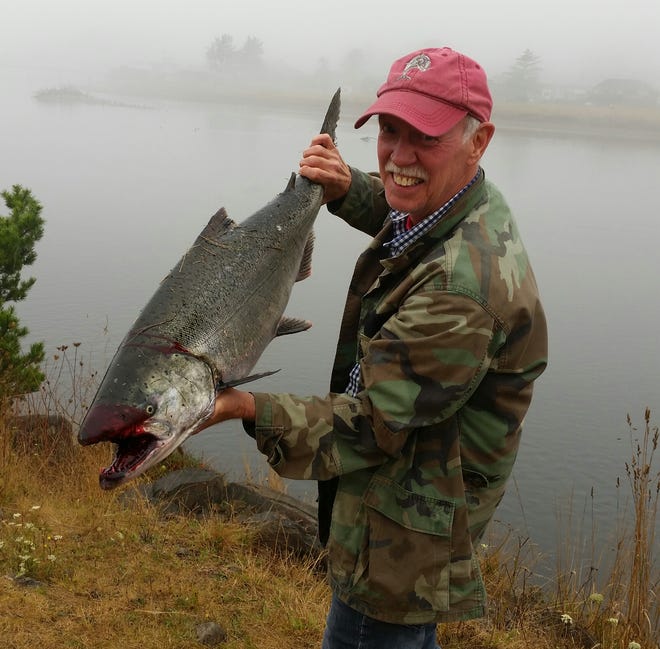 Ron Bryant of Mt. Angel hoists a hefty Chinook salmon that he caught at what’s known as the poggy hole.