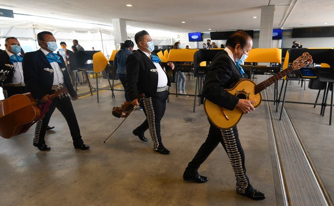 Members of a mariachi band walk past voting machines at the Dodger Stadium voting center during Election Day for the 2020 Presidential election between Democratic candidate, former Vice President Joe Biden and Republican candidate President Donald Trump. The mariachi band was there to serenade new citizens who were voting for their first time.