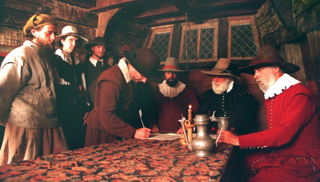 Actors re-create the signing of the Mayflower Compact aboard the Mayflower II at the Provincetown waterfront in 1995.