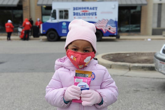 A young child holds free snacks outside an early voting site on Oct. 30, 2020 in Milwaukee.
