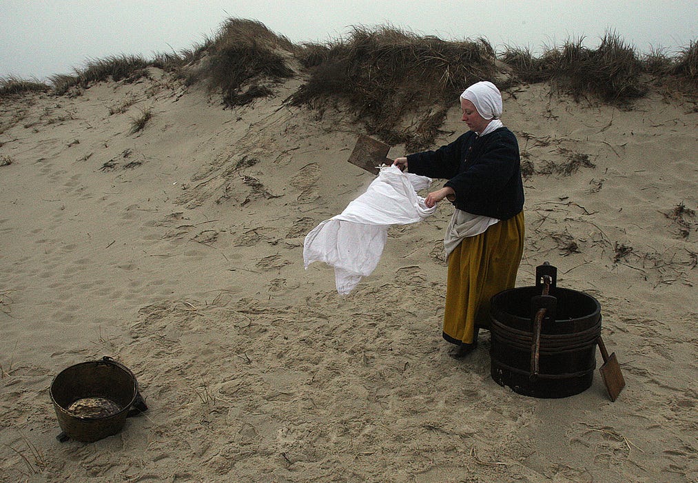 TRURO--031516-- Plimoth Plantation visits the Cape to study the Pilgrims' three exploratory trips and initial Native/Colonists interactions on their original landscapes. Kristen Haggerty took off her winter jacket and traded it for a Pilgrim outfit and washed clothes, reenacting the "first washing"  as part of a surprise for the tour.  Steve Haines/Cape Cod Times