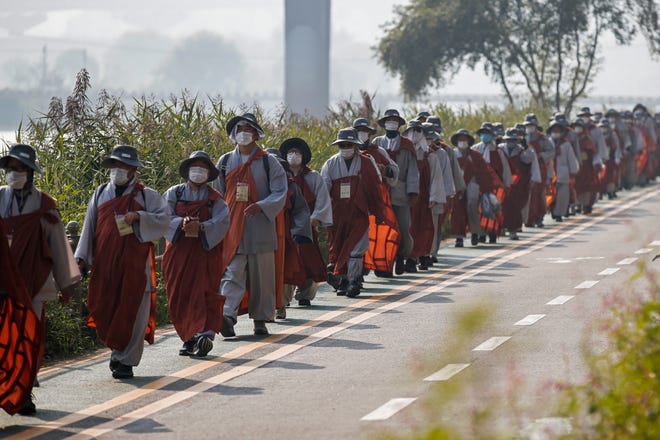 Buddhist monks and believers walk along a stream in Seoul, South Korea, Oct. 27.