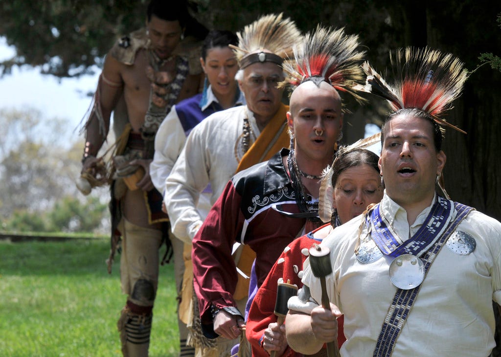 Jonathan Perry, right, a member of the Wampanoag Tribe of Gay Head (Aquinnah), leads a group of native dancers onto the stage at the Cape Cod National Seashore's Salt Pond Visitor Center in 2011 during a celebration of the tribe.