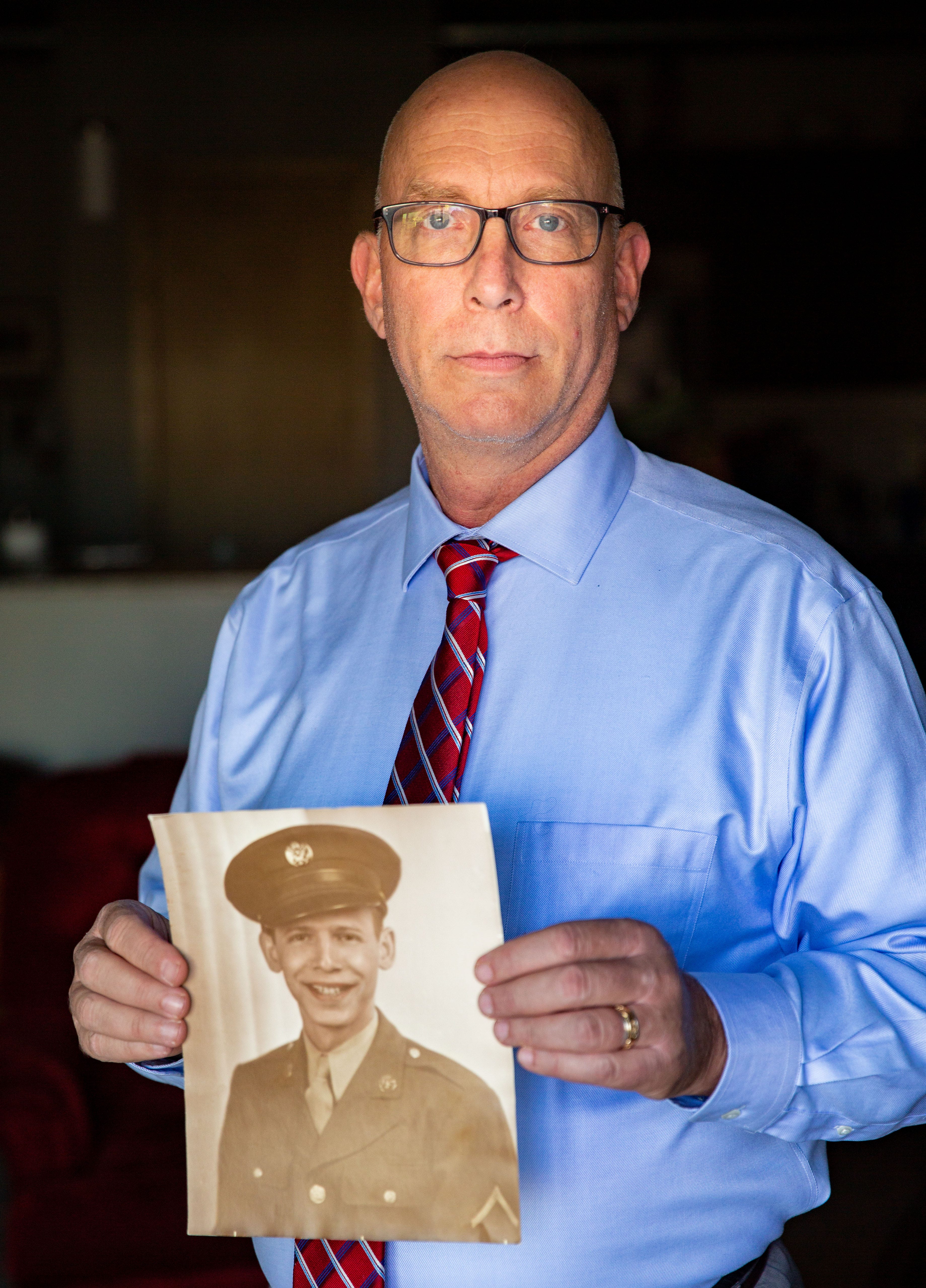 Ira Naiditch holds a photo of his father Sanford Naiditch at his home in Ankeny on Nov. 5, 2020. Sanford Naiditich served in the Army's 517th field artillery in World War II.