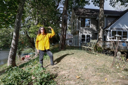 Rocky Ripple neighborhood homeowner Daniel Axler stands on the White River earth levy, demonstrating the height of a proposed flood wall which would sit atop the levy blocking his access and view of the river in Indianapolis, Wednesday, Sept. 30, 2020.  