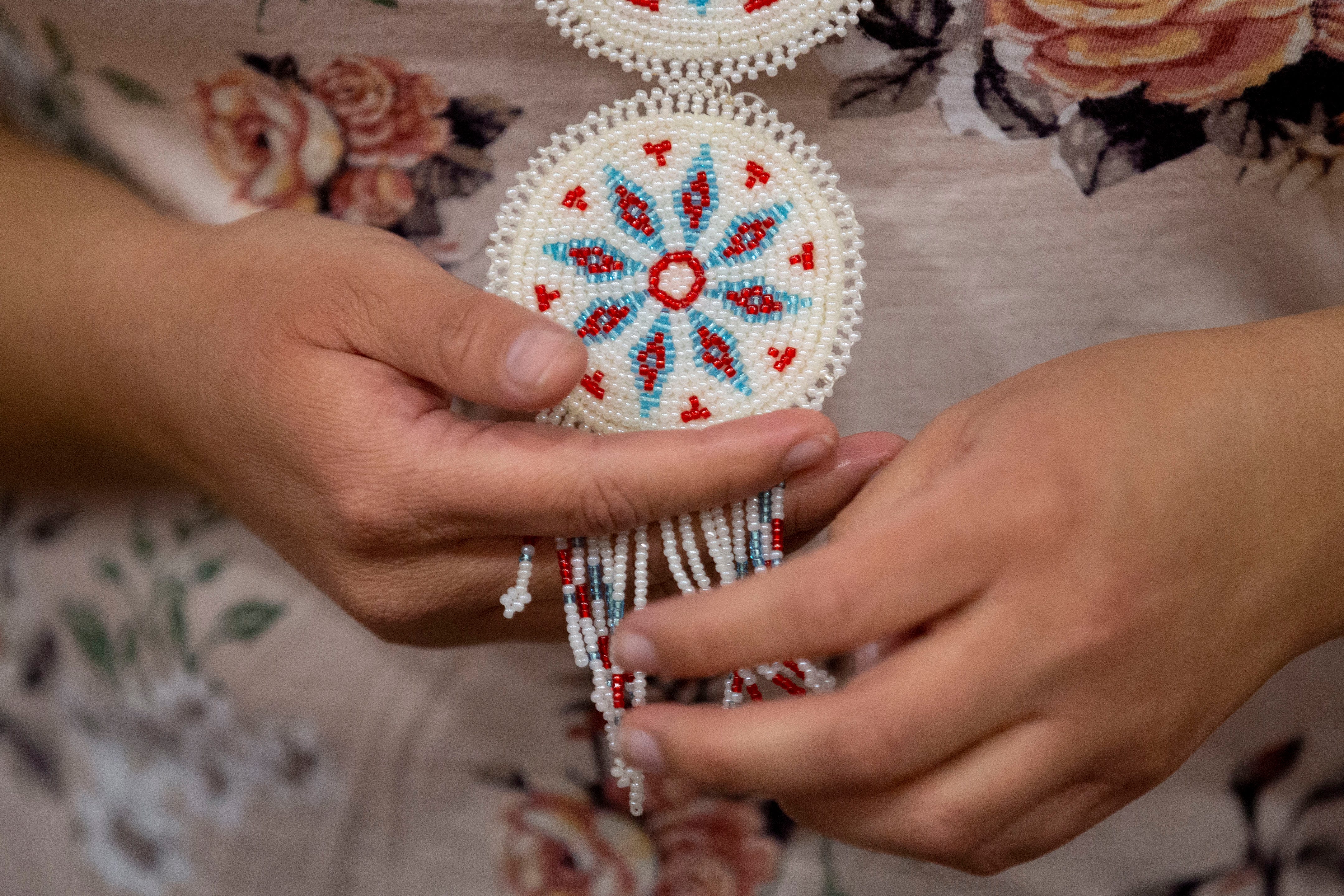 Andrea Thompson talks about her beadwork while holding on to her three-tiered medallion necklace Thursday, Nov. 5, 2020, at the Choctaw reservation in Henning.