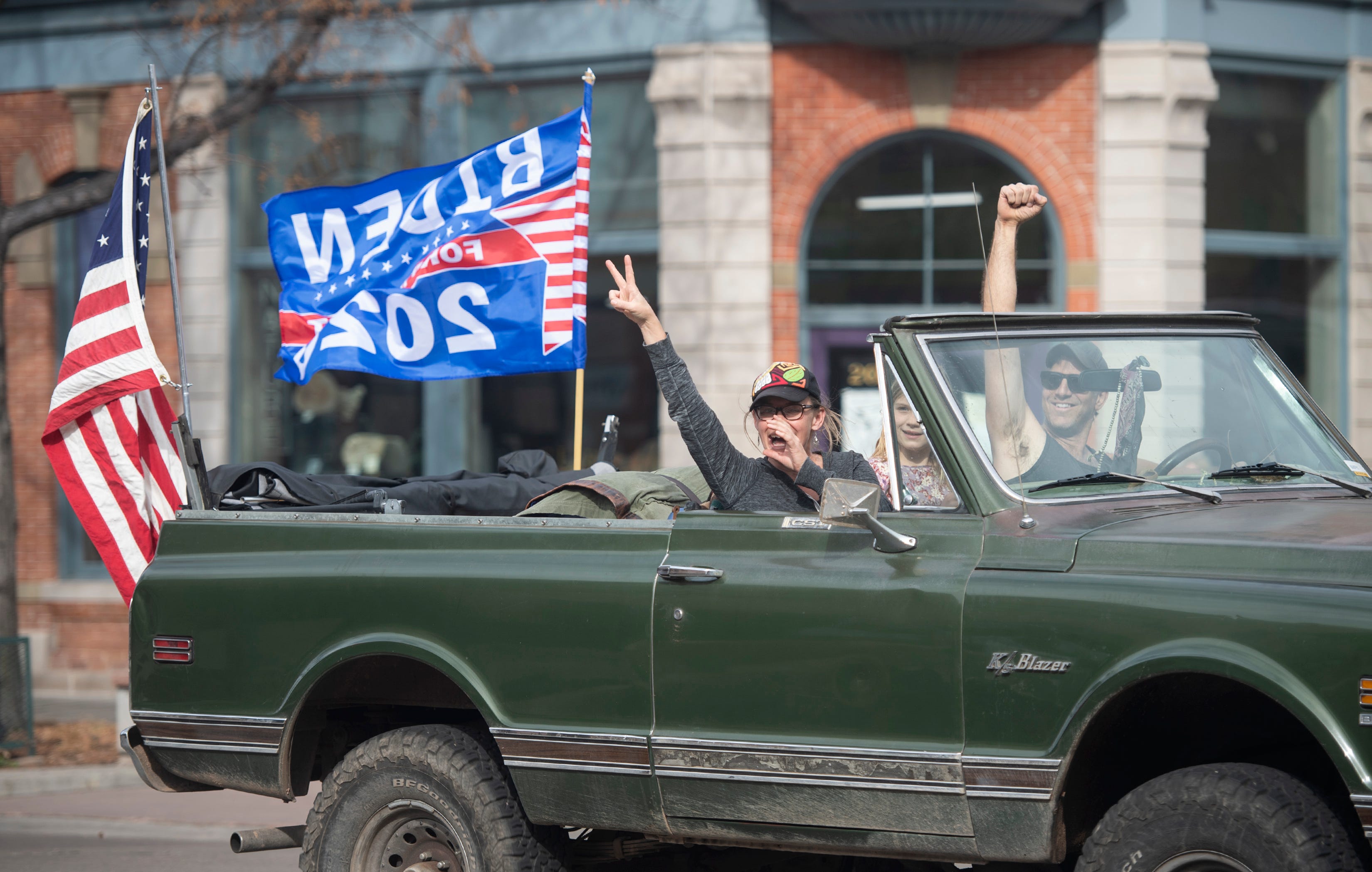 People cheer from their vehicle after Democratic candidate Joe Biden wins the 2020 presidential election in Old Town Fort Collins, Colo.