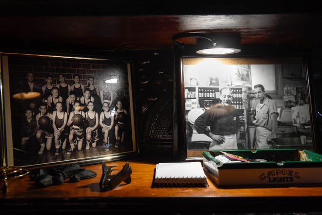 Photos on the shelves at Metzger's Tavern show a 1930s Holy Name Elementary basketball team and previous owners John Metzger with his son, Don Metzger, taken in the 1940s when the tavern sold groceries.