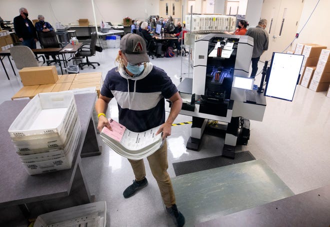 Maricopa County Elections Department employee Charles Cooley tabulates ballots at county elections headquarters in Phoenix on Nov. 9, 2020.