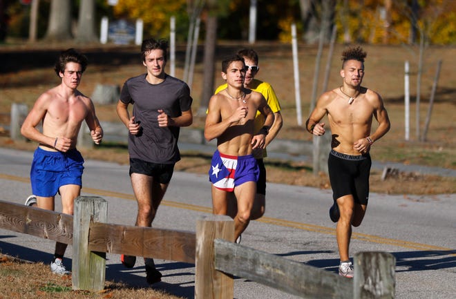 Members of the St. Raphael boys cross country team work out with a run through Pawtucket's Slater Park on Tuesday afternoon — the fifth day in a row of record-breaking November heat.