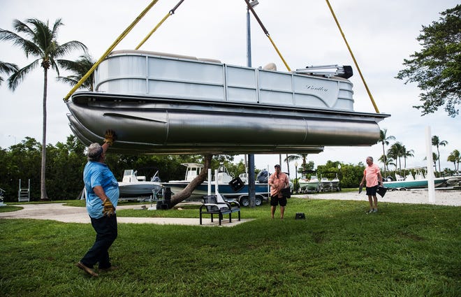 Gordon Centilla, left, owner of Gordon Crane Company places boats Monday, November 9, 2020 for Boaters Paradise at Centennial Park in preparation of the Fort Myers Boat Show. helping are Boaters Paradise owner, Wally Hunter, right, and General Manager Scott Irvin, center. The boat show gets underway on Thursday in downtown Fort Myers and at Centennial Park.