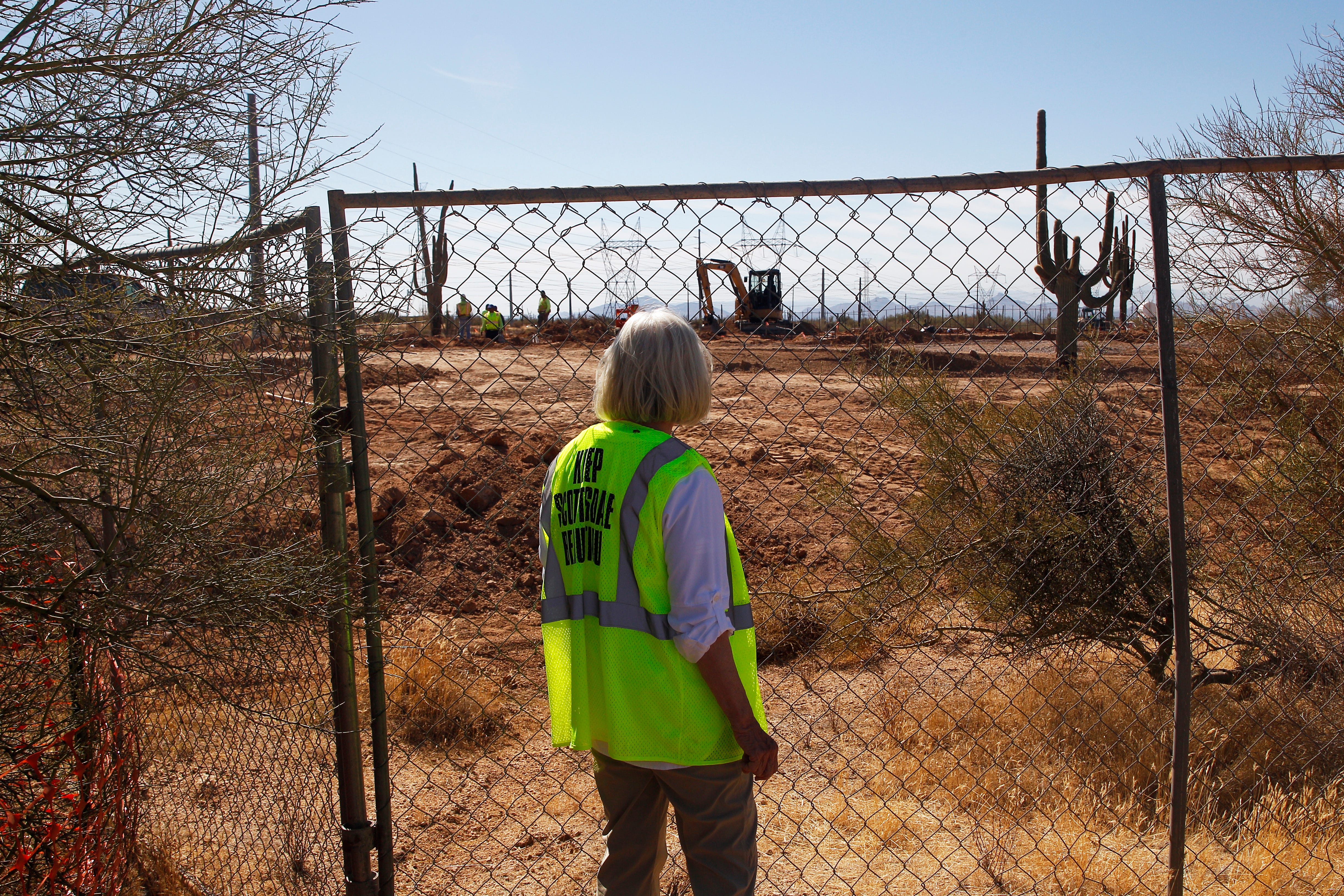 McDowell Sonoran Conservancy volnteer Debbie Langenfeld observes construction, which has destroyed biocrust inside a nature preserve.