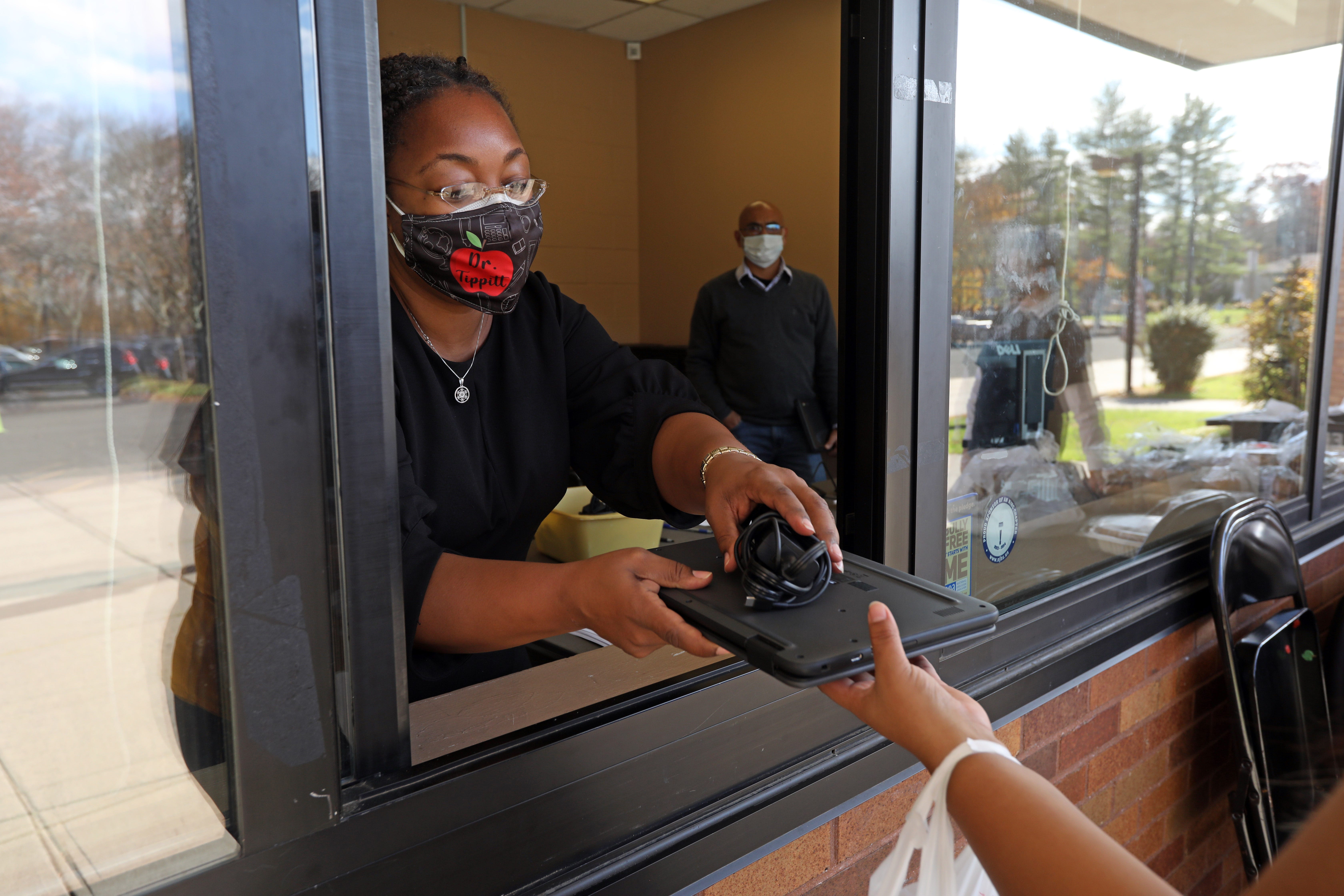 Assistant Principal Monifa Tippitt distributes a Chromebook Nov. 10 at Chestnut Ridge Middle School in Chestnut Ridge, New York. The school is part of the East Ramapo Central School District.