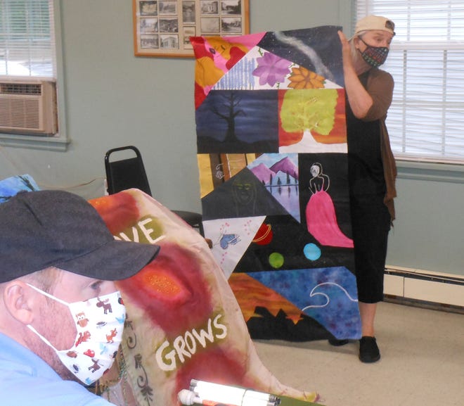 Laura Guzda shows examples of the 33 fabric art panels to the Hawley Parks & Recreation board, June 30. The panels went up the next day at the tennis court in Bingham Park. The Community Tapestry Project is expected to be shown there until about July 10. Parks & Rec member Mike Dougherty is in the foreground.