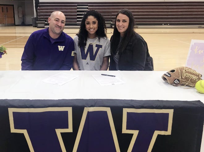 Lee's Summit North senior Kinsey Fiedler, one of the top softball recruits in the nation, poses with her parents Jason and Lacey after signing with the University of Washington Wednesday.