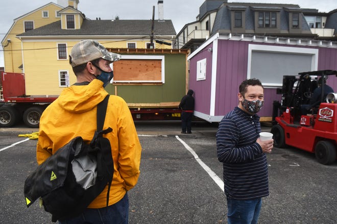 The buildings of PopUp NH were moved Thursday morning from the Bridge Street parking lot to a lot on Commerce Way where they will be stored for the winter. Josh Denton, left, director of PopUp NH, and Andrew Bagley, the group's secretary, made sure the move went smoothly.