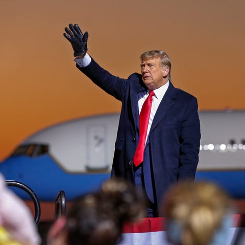 President Donald Trump waves farewell to the crowd