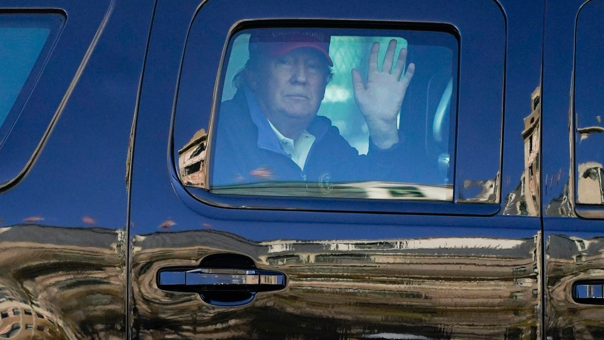 President Donald Trump waves to supporters from his motorcade as people gather for a march Nov. 14, 2020, in Washington.