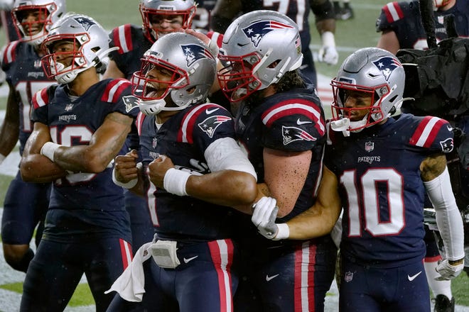 New England Patriots quarterback Cam Newton, center, celebrates his rushing touchdown with teammates in the second half of an NFL football game against the Baltimore Ravens, Sunday, Nov. 15, 2020, in Foxborough, Mass.