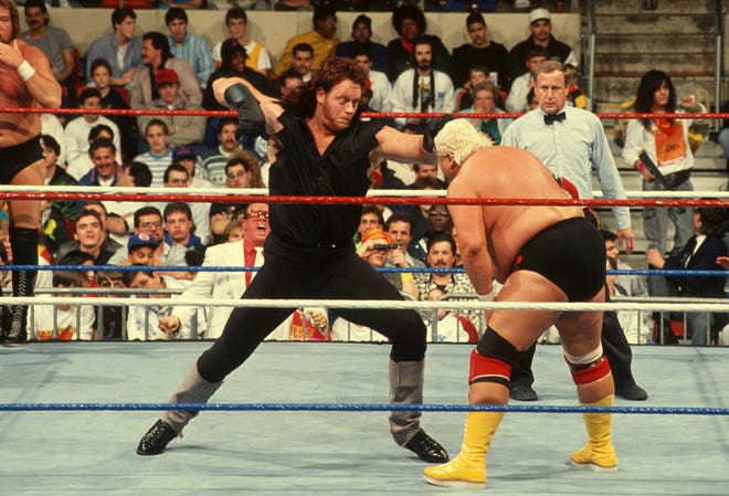The Undertaker (left) battles Dusty Rhodes in his debut at the 1990 Survivor Series.