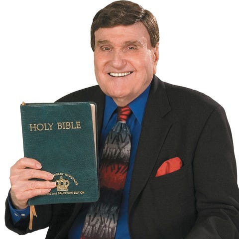 The Rev. Ernest Angley poses with a Bible in 2006.