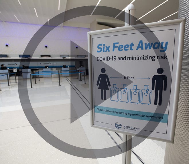 In this file photo, A sign warns travelers to maintain a safe social distance at John Glenn International Airport in Columbus on Thursday, April 2, 2020. The airport has seen a significant drop-off in traffic due to travel restrictions for the COVID-19 coronavirus pandemic.