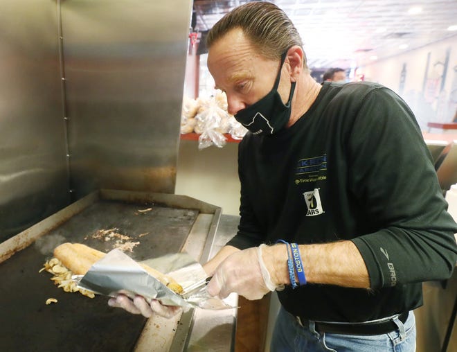 Eddie Sutter, owner of Eddies Famous Cheesesteaks & Grille, prepares a chicken cheesesteak sandwich at his restaurant in the Delaware Building in downtown Akron.