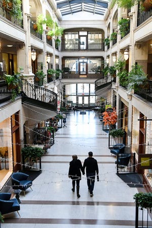 A couple walks through a quiet Grove Arcade, usually bustling with shoppers, November 17, 2020.