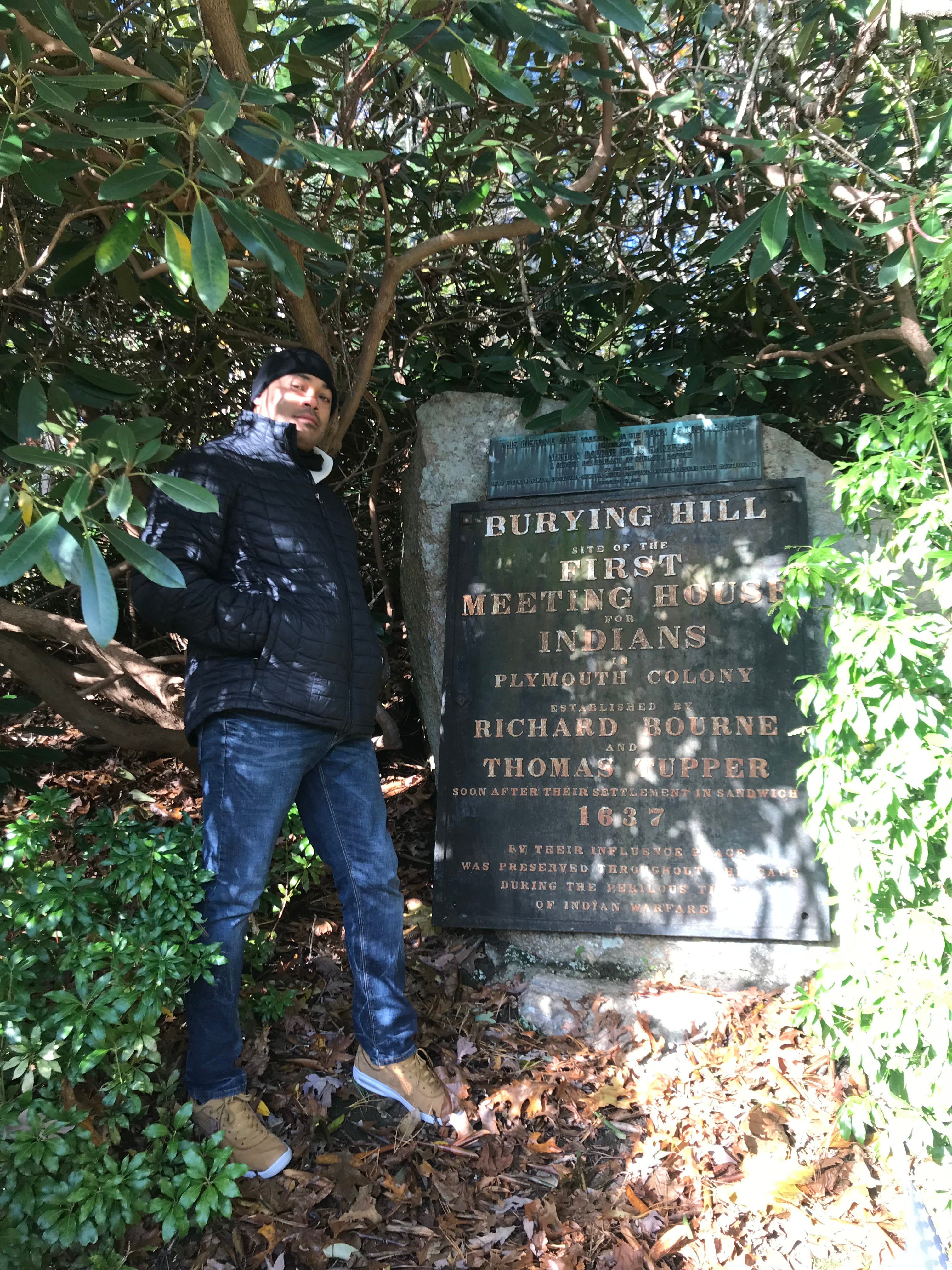 Troy Currence, Herring Pond Wampanoag medicine man, stands next to a monument at the Herring Pond Wampanoag burial grounds.