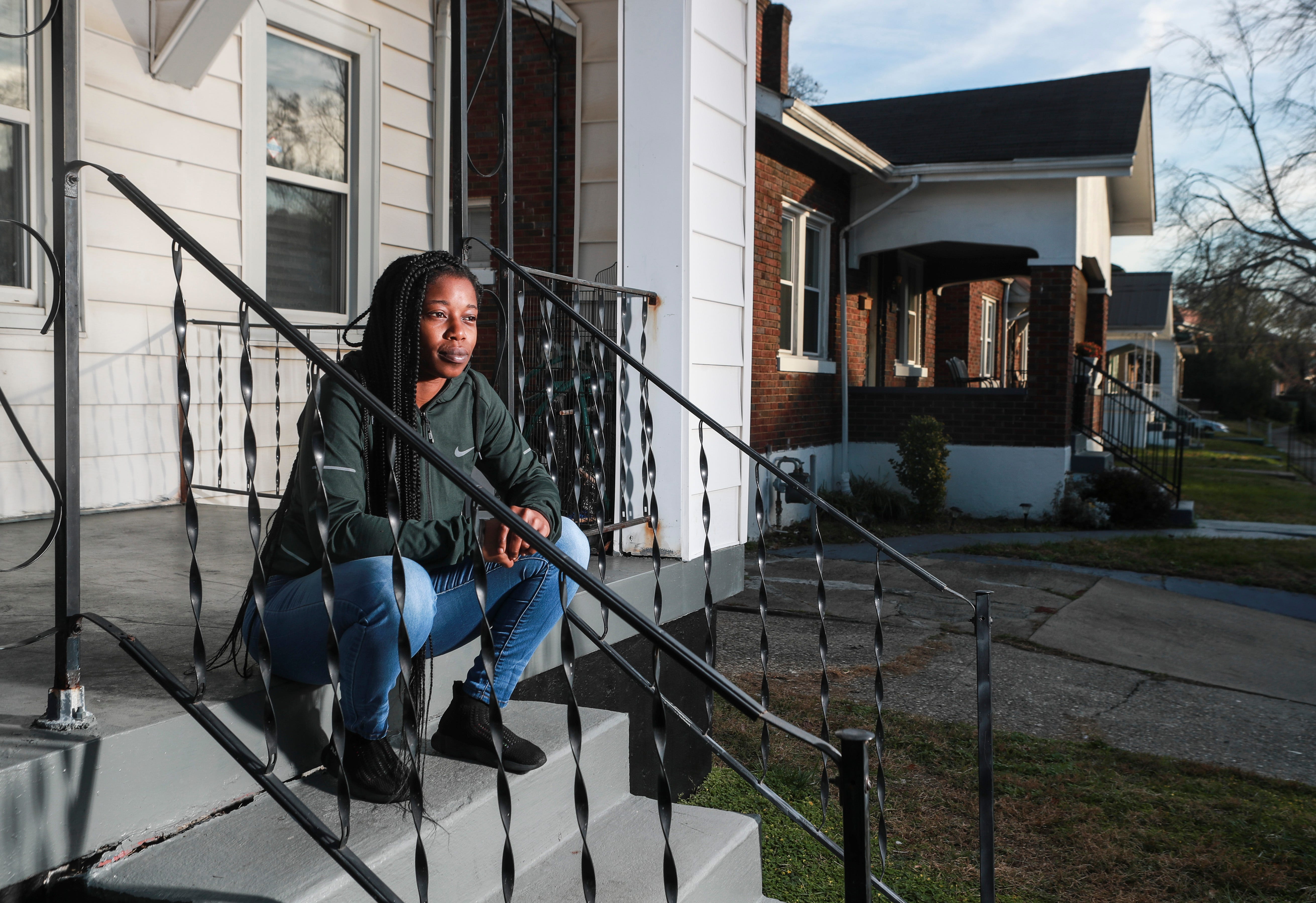 Kwmisha Adams sits on the steps of a home she recently moved to after being evicted from her former apartment, not for unpaid rent but because of a dispute the property manager had with her parking her disabled car — which was involved in an accident and had a broken radiator — in the complex's parking lot. She now lives in west Louisville with her four young boys. Nov. 19, 2020