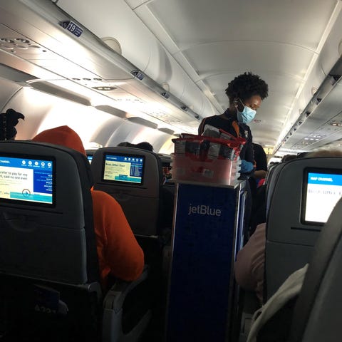 A JetBlue Airways flight attendant serves passenge