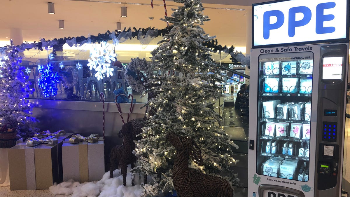 Sign of the times: The holiday display in the JetBlue Airways terminal at JFK AIrport in New York is stationed next to a vending machine that sells personal protective equipment.