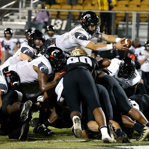 Cincinnati quarterback Desmond Ridder (9) dives ov