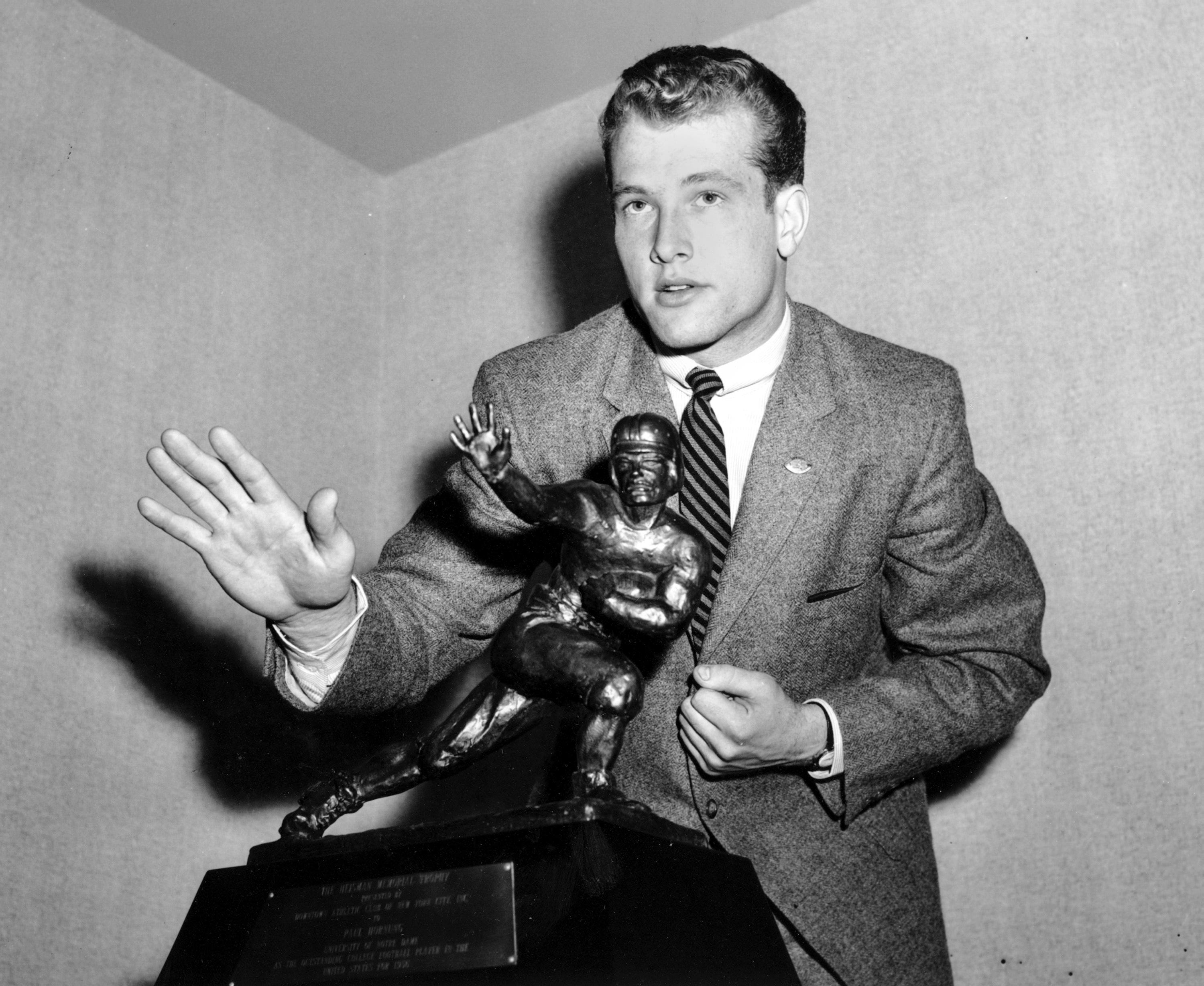 This Dec. 12. 1956, file photo shows Notre Dame quarterback Paul Hornung imitating the posture of the Heisman Trophy that he received at the Downtown Athletic Club in New York City. Hornung, the dazzling “Golden Boy” of the Green Bay Packers whose singular ability to generate points as a runner, receiver, quarterback, and kicker helped turn them into an NFL dynasty, has died, Friday, Nov. 13, 2020. He was 84.