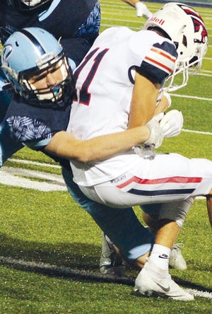 Jensen Laws, left, makes a strong tackle for Bartlesville High School.