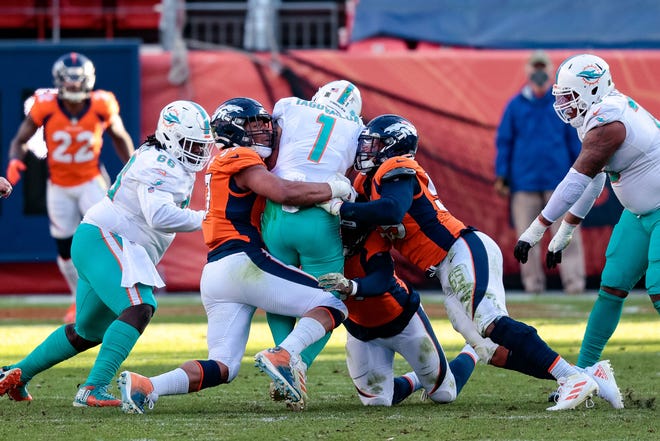 Nov 22, 2020; Denver, Colorado, USA; Miami Dolphins quarterback Tua Tagovailoa (1) is sacked by Denver Broncos defensive end DeMarcus Walker (57) and outside linebacker Bradley Chubb (55) and outside linebacker Malik Reed (59) in the second quarter at Empower Field at Mile High. Mandatory Credit: Isaiah J. Downing-USA TODAY Sports