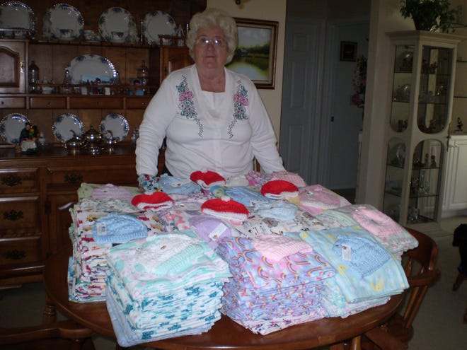 COVID-19 did not stop Fairfield Harbour Hospital Auxiliary members from sewing and completing the annual delivery of 150 flannel baby blankets and coordinated knitted baby hats to CarolinaEast. Lucille Durst, baby blanket and hat chairperson for the Auxiliary, posed with the finished sets prior to delivery. Extra hats and red Christmas hats were also sent in. In normal times, the sets would have been delivered directly to the nursery, but this year they were dropped off at the entrance. [CONTRIBUTED PHOTO]      