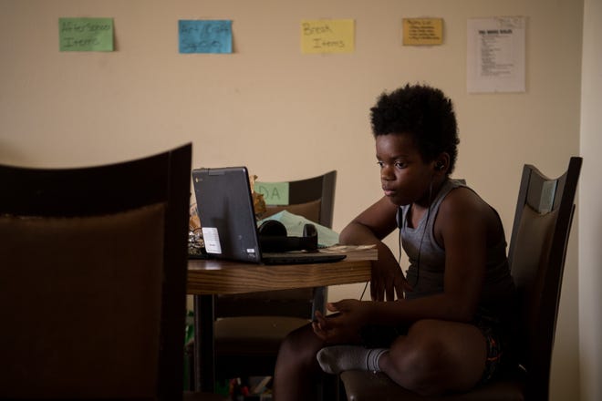Malik Gordon, a sixth grader at Nashville Classical Charter School, works on his laptop during remote learning at home in Nashville, Tenn., Wednesday, Nov. 18, 2020.